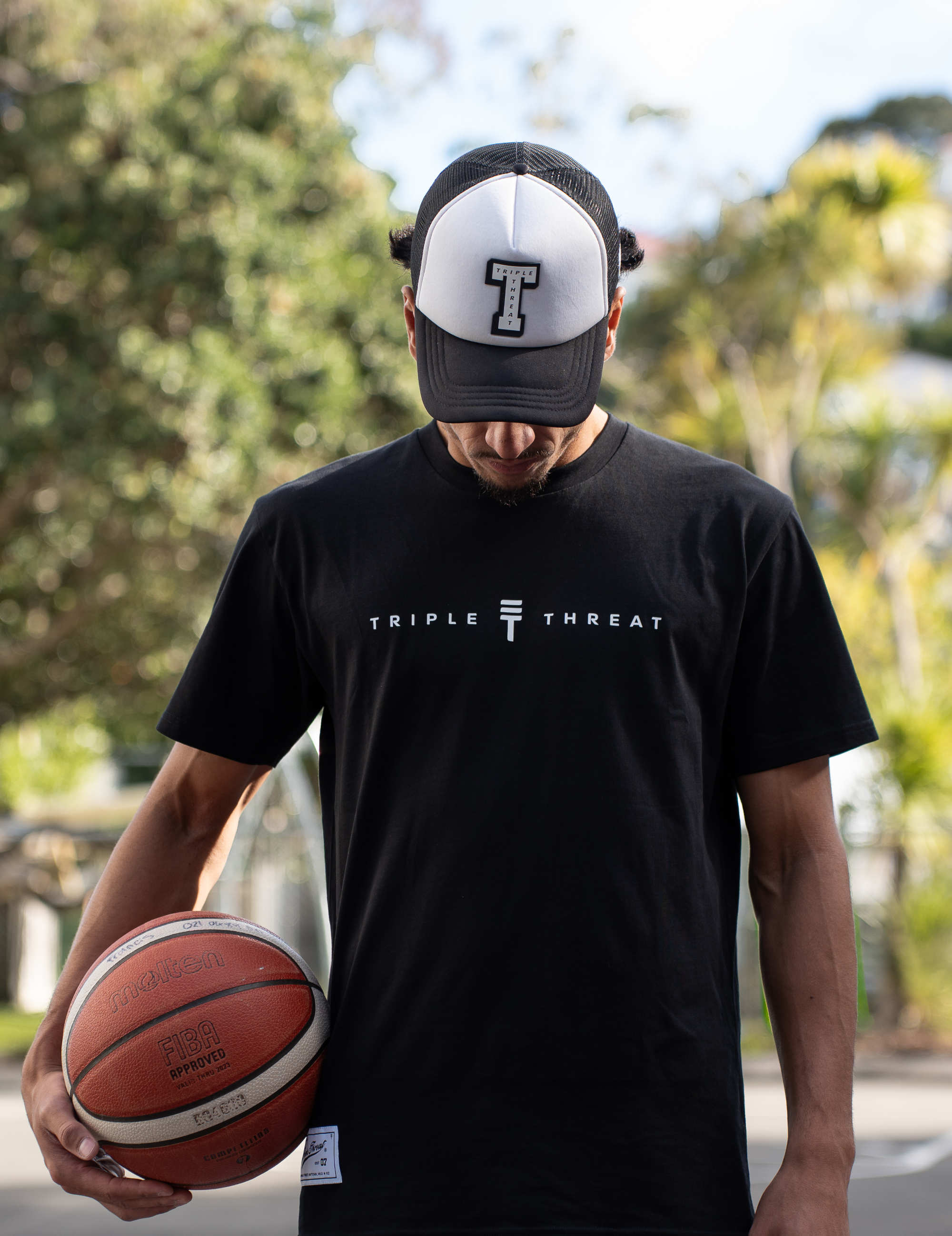 Model wearing Triple Threat hat with basketball