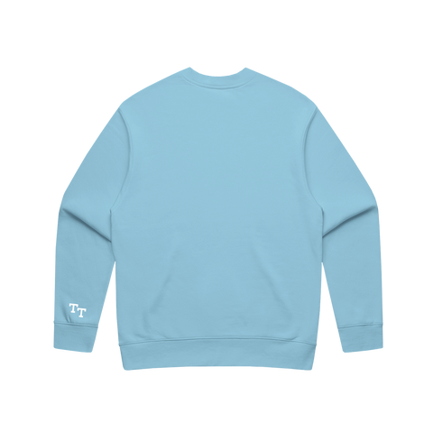 back of baby blue sweater with 'TT' embroidered in white on the bottom left sleeve 